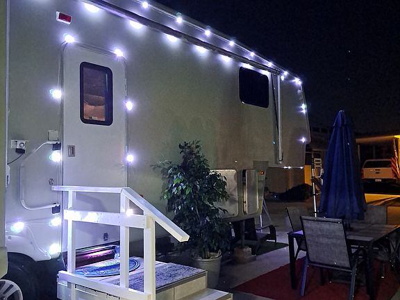 Entrance to the RV. It's illuminated at night. Also, outside eating area with umbrella.