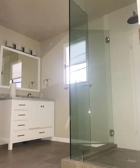 Bathroom with walk-in shower and marble countertop.