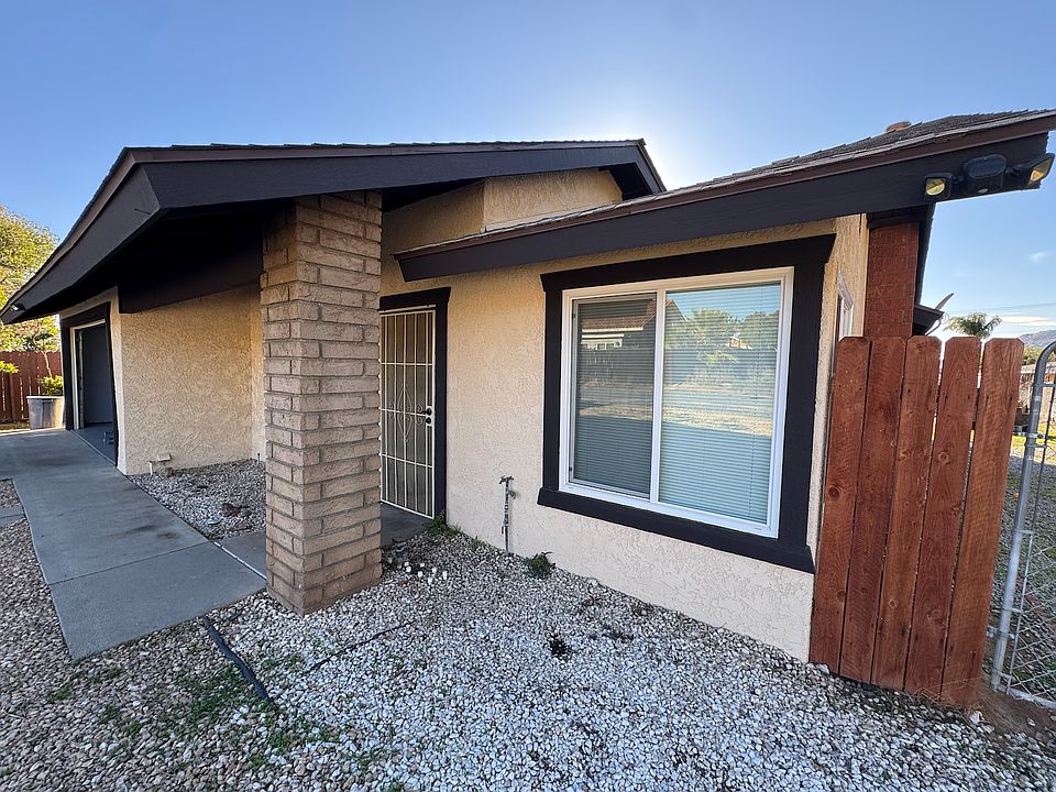 Front facing of home; large window and fireplace in living room; security door