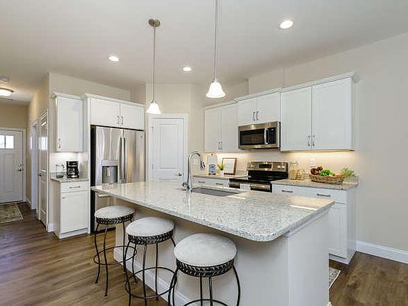 Granite counter tops, island and breakfast bar. Coffee bar next to refrigerator.