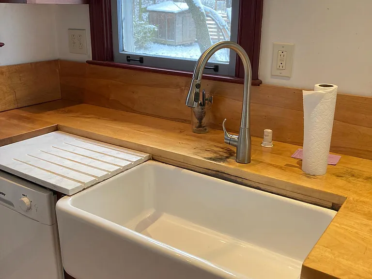 Large farmhouse sink with a window to look outside while washing dishes.