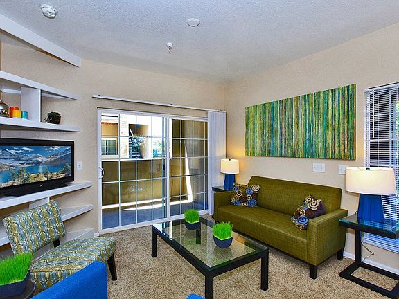 Living room with a coffee table, a couch, plush carpeting, and view of the outside.
