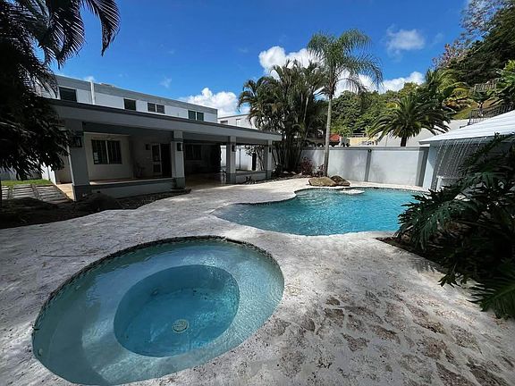Resort back yard pool with beach entrace , insde stool, table for food or drinks, access to bar arrea with two fountains .