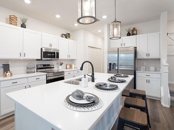 Fall in love with your new kitchen with a counter-height island and a large pantry - Aria home plan