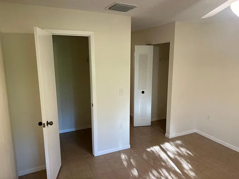 Bedroom view facing the door, both closets visible.