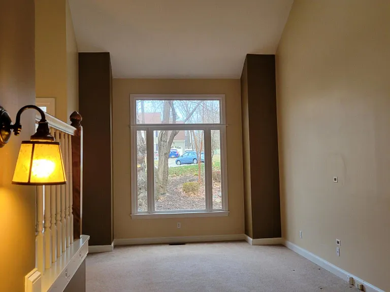 Looking from formal dining room into formal Living room with 2 sky lights and a cathedral ceiling