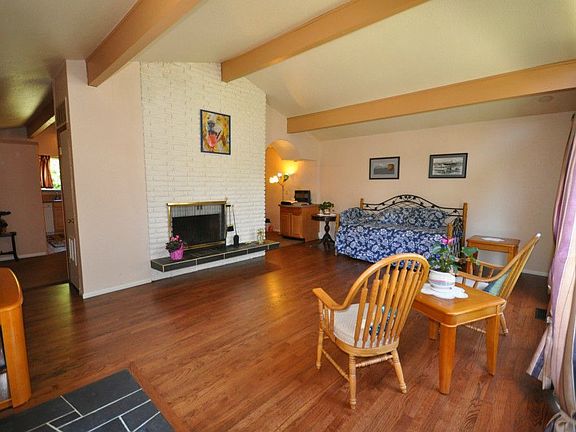 Bright and spacious living room with wood burning fireplace. Original hardwood floors, beautifully restored. 
