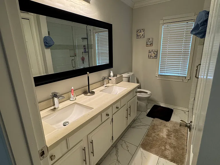 Generous sized 2nd bathroom with new tile floor, double sink, quartz countertop and new frameless walk-in shower