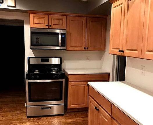 Large kitchen with stainless steel appliances, tons of cabinetry, and quartz countertops. There is a gas range and the lower cabinets have pullout drawers that are convenient.