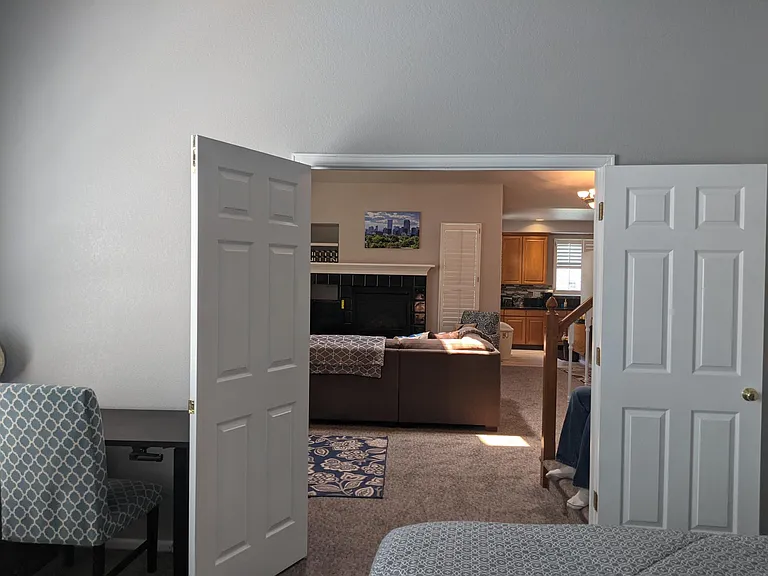 Looking out double french doors of Primary suite to Living room