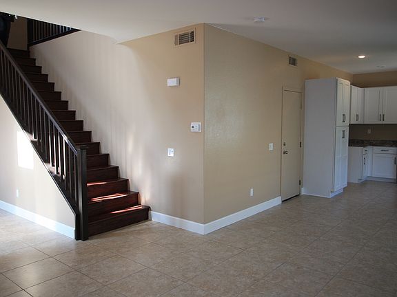 View from family room looking toward kitchen and stairs. Door shown leads to attached garage.