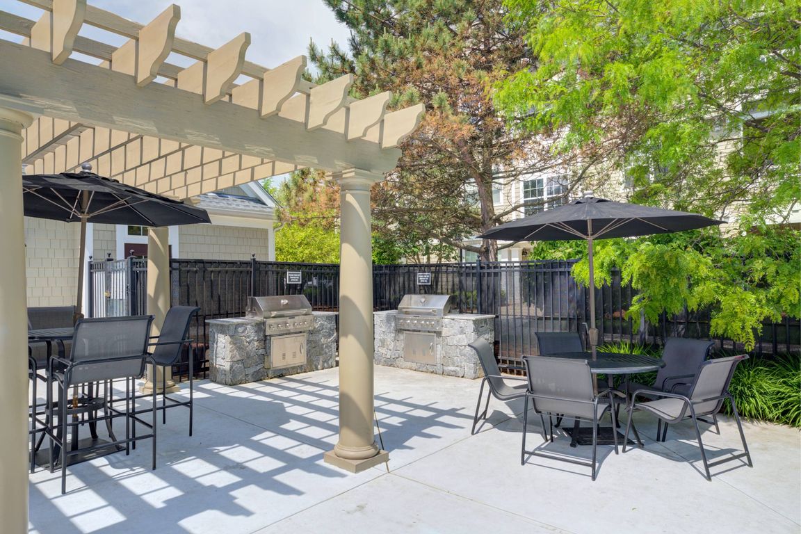 Outdoor grilling area with two grills and table and chairs surrounding.