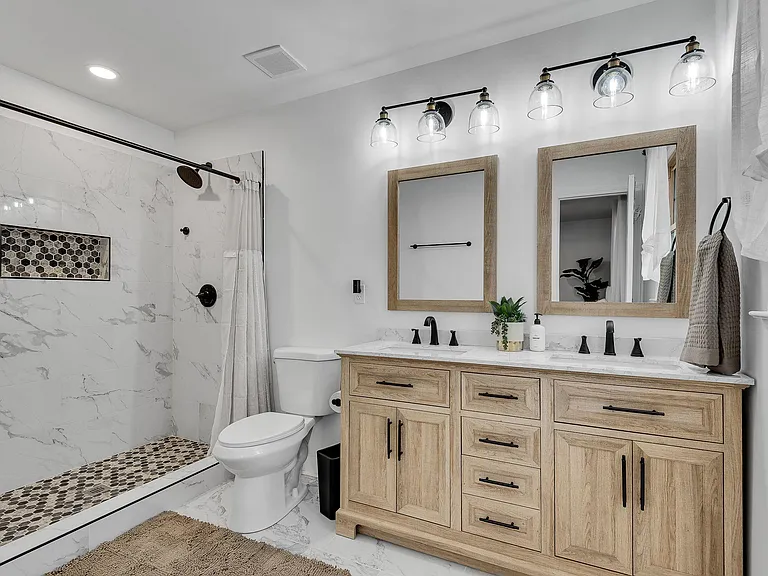 The double vanity close up: Warm wood, two sinks, black fixtures. Every detail chosen with care.