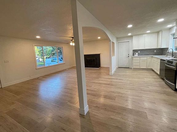 Living room from near rear sliding door. View of open-floor plan kitchen.