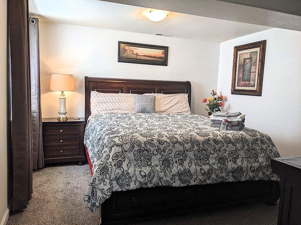 Spacious B1 bedroom with a king-size bed, night stand and lamp, decorated in a classic theme.