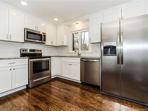 Beautiful kitchen with new cabinets with brushed nickel hardware, new stainless steel appliances (oven/range, dishwasher & refrigerator, microwave), new sink & faucet, new granite counters, new hardwood flooring, new window, new plumbing, updated electric