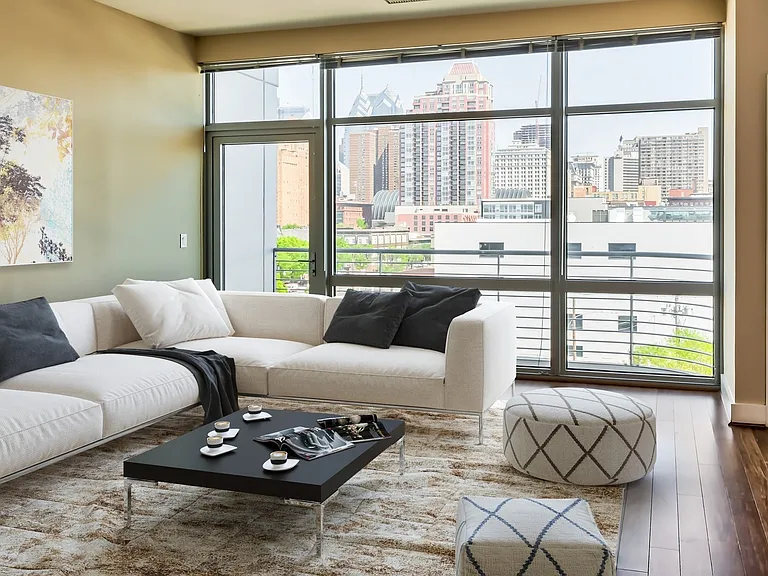 Spacious living area with floor-to-ceiling windows and wood flooring