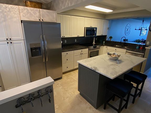 Updated kitchen with new stainless appliances, quartz and granite countertops, center island, desk/bar area too with wine fridge.