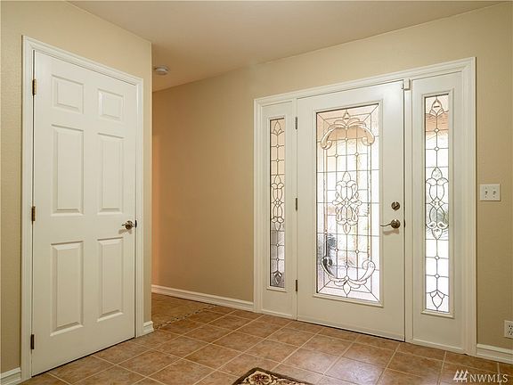 Inside the beautiful entry with large coat closet, shelving for shoes and durable ceramic tile flooring