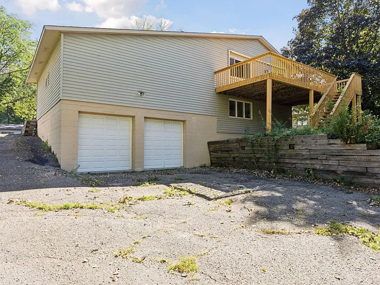 The wraparound driveway leads to a heated garage below