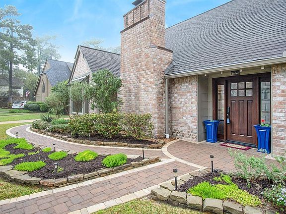 View of the beautiful front door area with paver paths and lush landscaping.