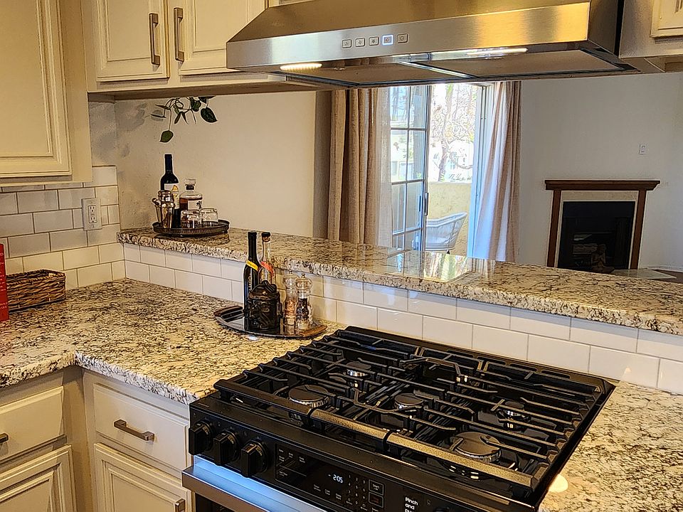 Passthrough kitchen layout with built-in 5 burner stove & raised counter area for effortless entertaining.