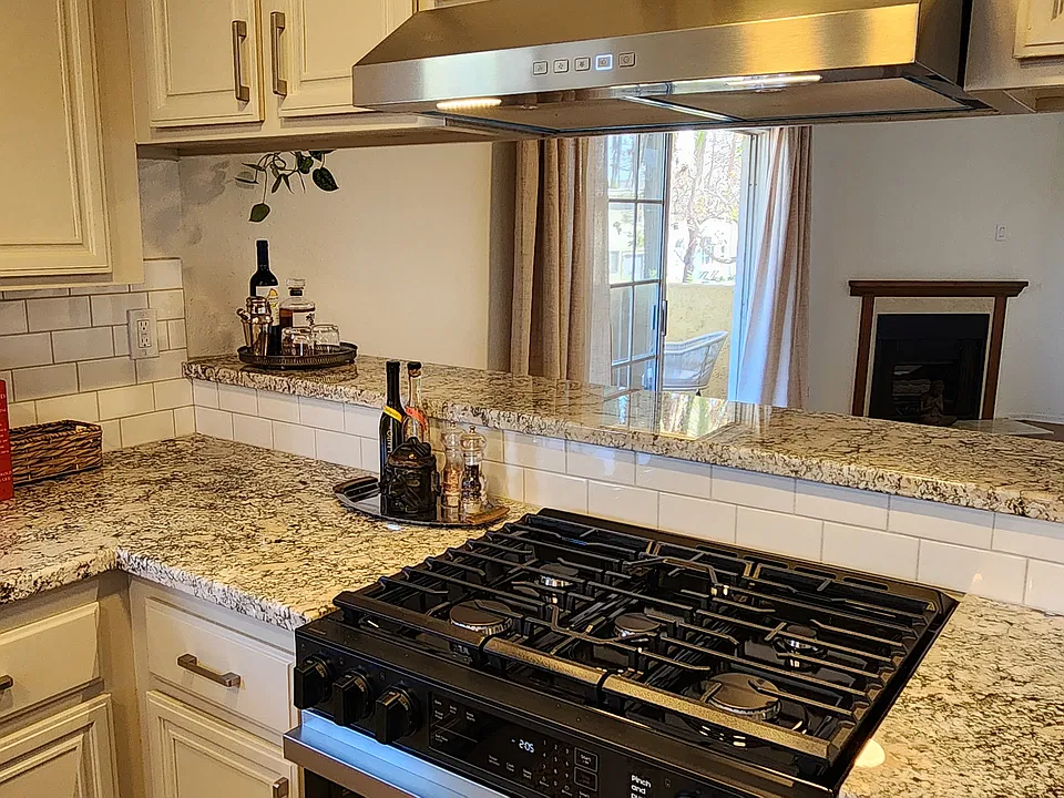 Passthrough kitchen layout with built-in 5 burner stove & raised counter area for effortless entertaining.