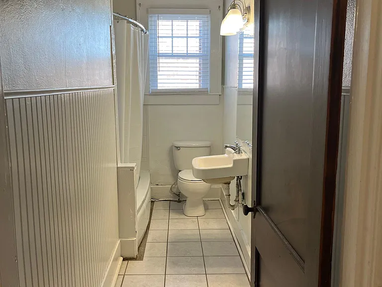 Bathroom with tub/shower combo, tile flooring and bead board