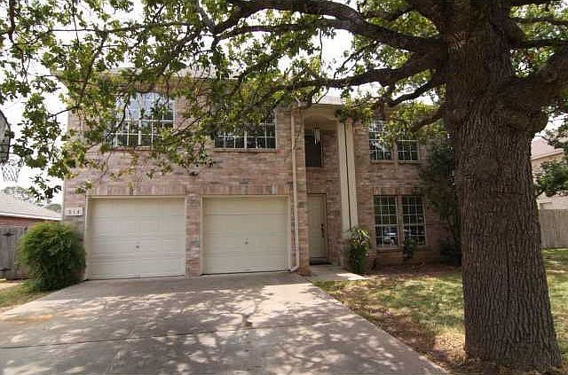 beautiful brick exterior shaded by ancient oak tree