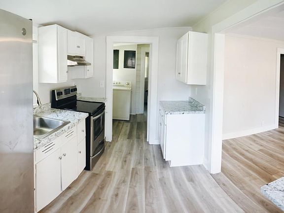Panoramic photo of kitchen and living room.