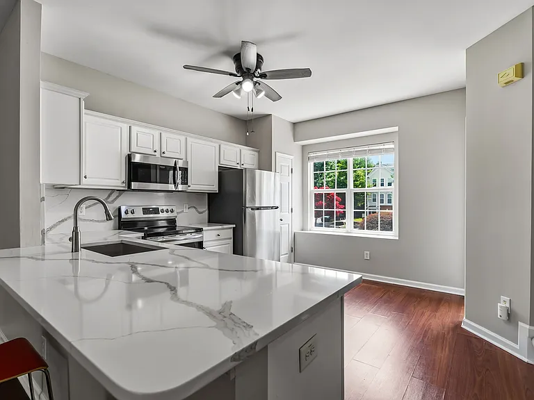 Kitchen view from stairs that shows a peninsula that can be used for eating, socializing, working, and so much more.