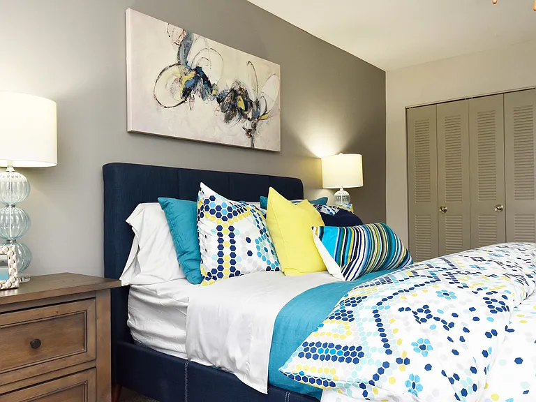 Experience serene comfort in this contemporary bedroom, adorned with vibrant accents and artistic flair.