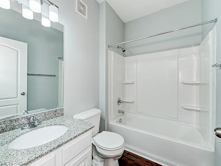 This spacious bathroom features a large vanity and full-size shower/tub combo_style and function come together effortlessly.