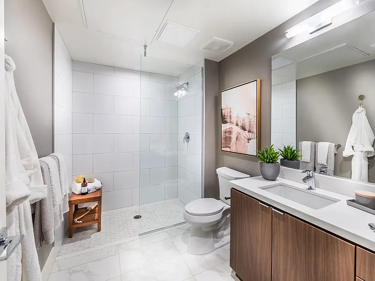 Frameless glass shower with tile surround and sleek fixtures.