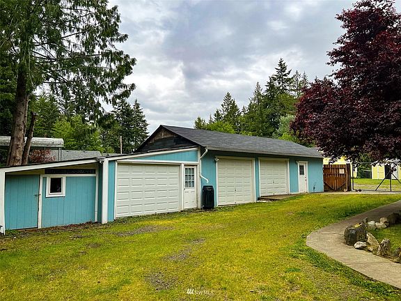 Huge garage with 3 bays and lots of extra storage space.  Location gives privacy from other neighbors. Garden shed at the end.  Gated entry to the driveway.>