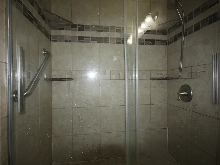 Large walk in shower in Primary bath with decorative tile walls