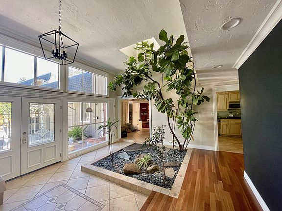 Wall of windows in the entry atrium looking into the kitchen with fireplace wall on the right.
