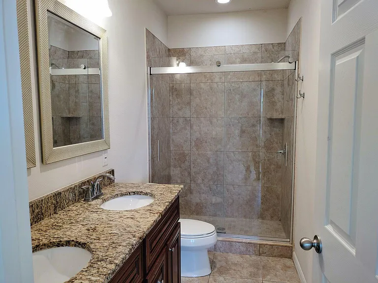 Master bathroom with dual vanity sinks and glass walk in shower