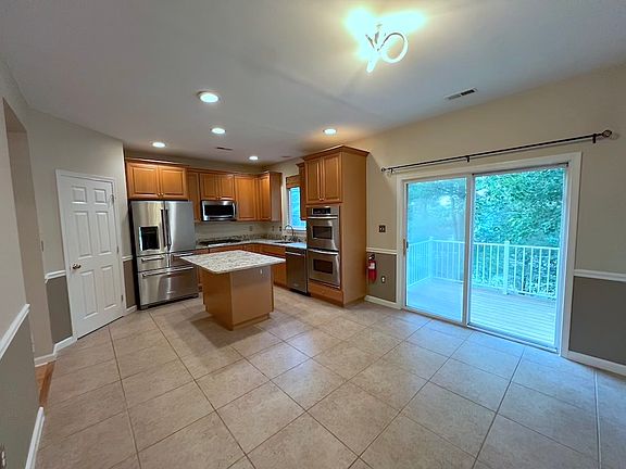 View of breakfast area and sliding glass door to deck, view of trees
