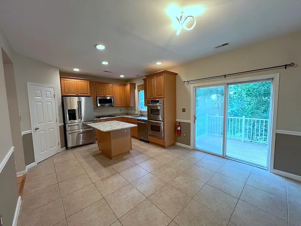 View of breakfast area and sliding glass door to deck, view of trees