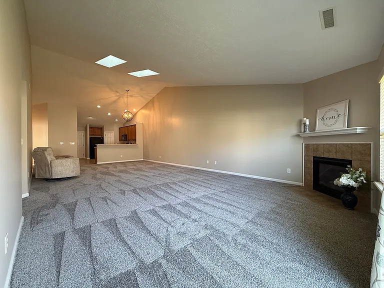 Spacious living area with gas fireplace and vaulted ceilings with skylights.