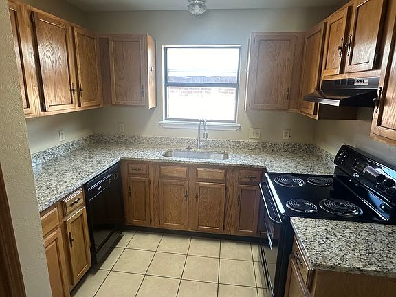 Kitchen area with new granite countertops, stove and dishwasher