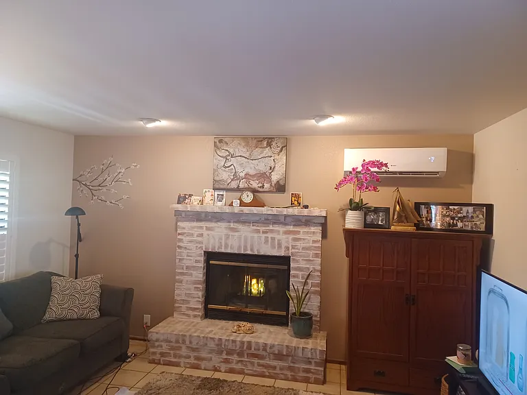 51" TV is now located above fireplace and new couch is moved to face TV, wood burning fireplace