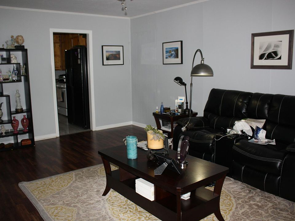 Roomy living area with beautiful flooring and ceiling fan.