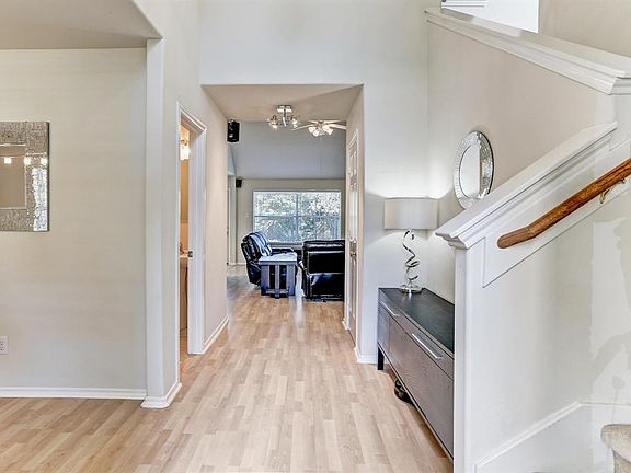 The entry way features tall ceilings, and a view of both the formal dining room and family room.