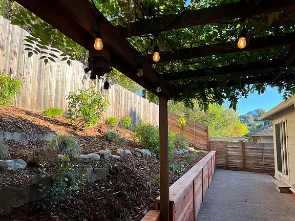 newly landscaped brick patio and garden with trellised seating