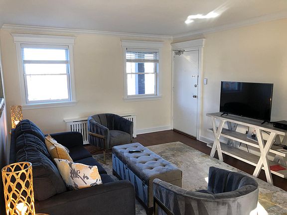 Living room with optimum TV, and condo entrance door. Outstanding view of Deal Lake