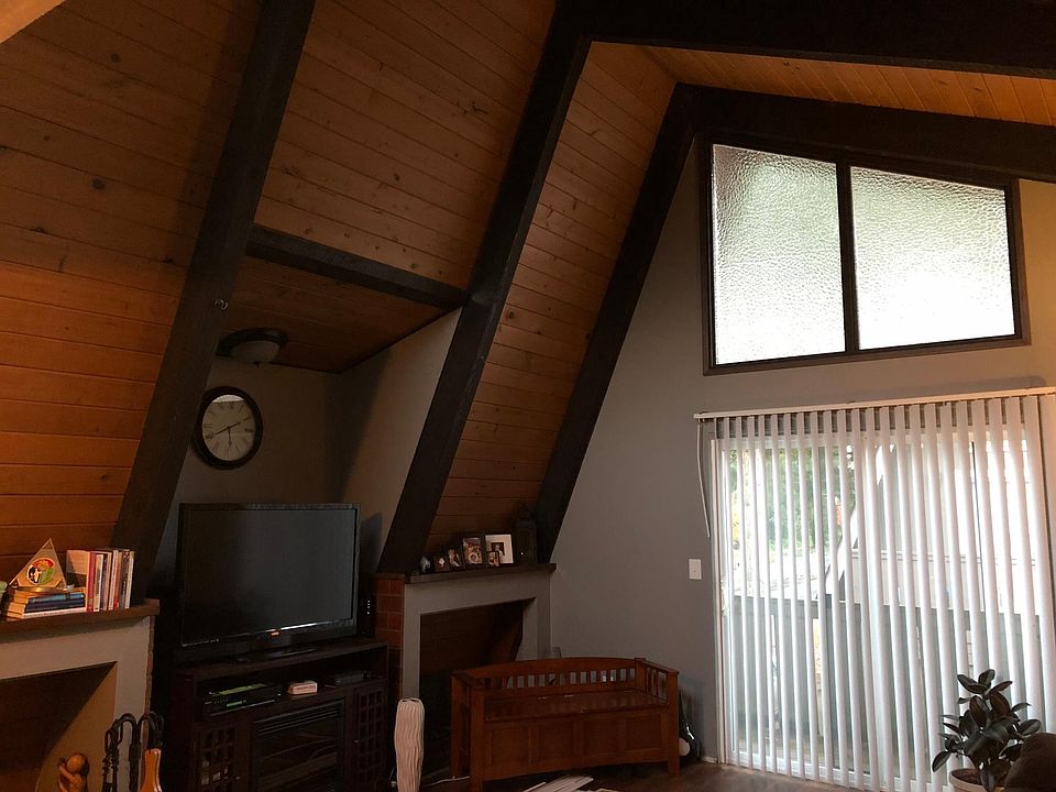 Living room has lots of natural light, vaulted wood ceilings. Enjoy your morning coffee on the deck!