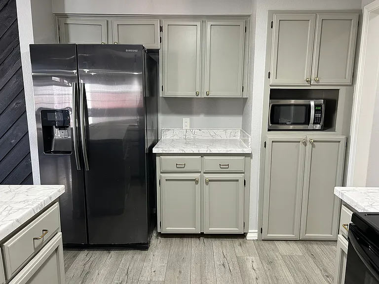 Lots of cabinets, large refrigerator.
