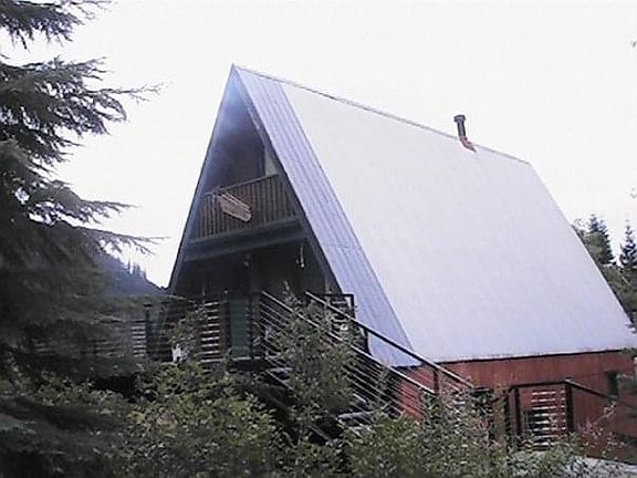 Entrance of home with a small creek, and large deck